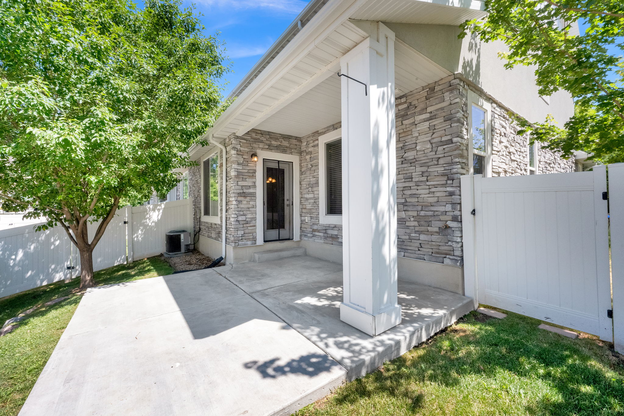 Covered patio featuring a concrete slab and stone veneer exterior