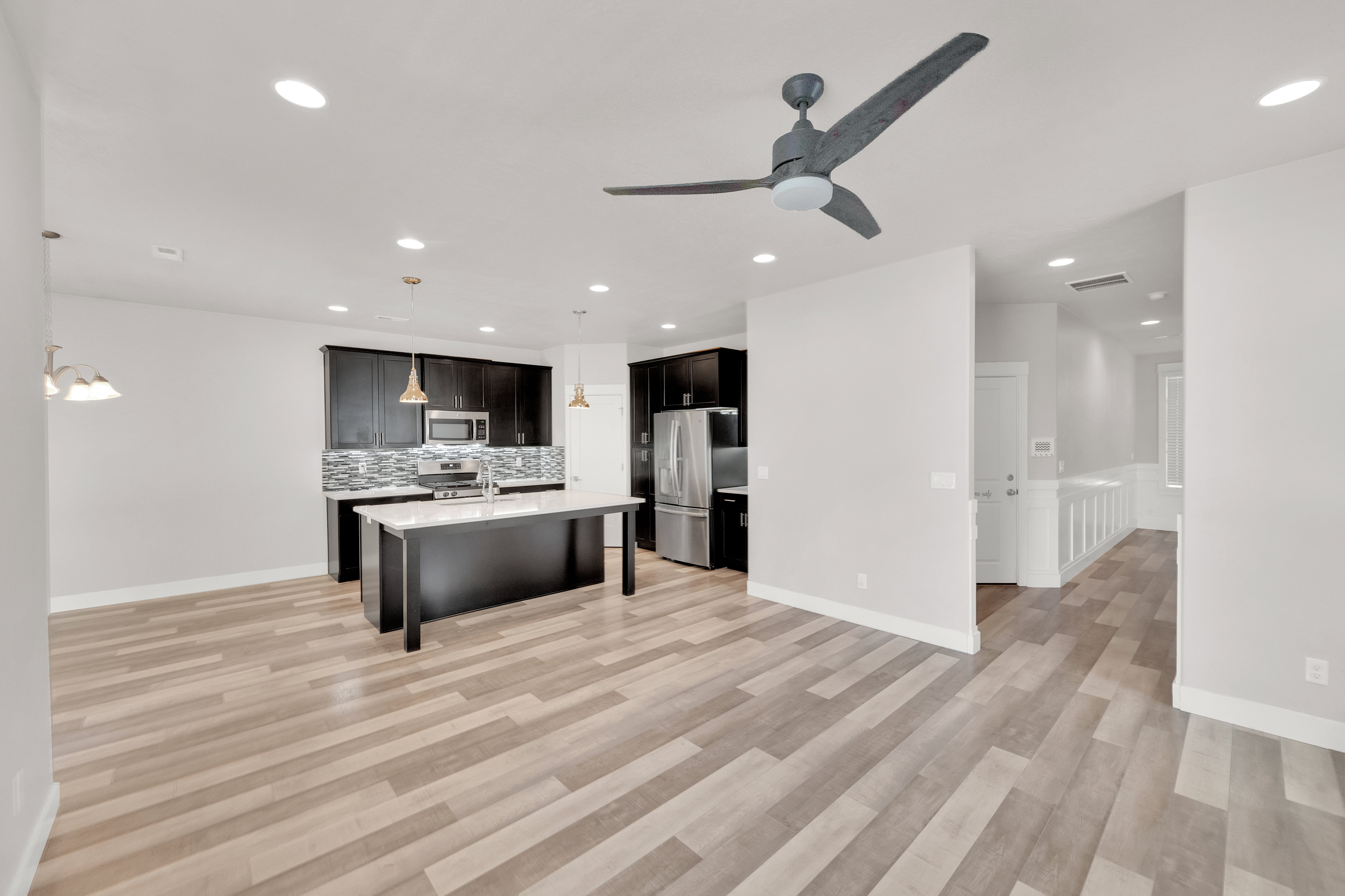 Open-concept living space featuring wood-finish flooring, recessed lighting, and a contemporary ceiling fan