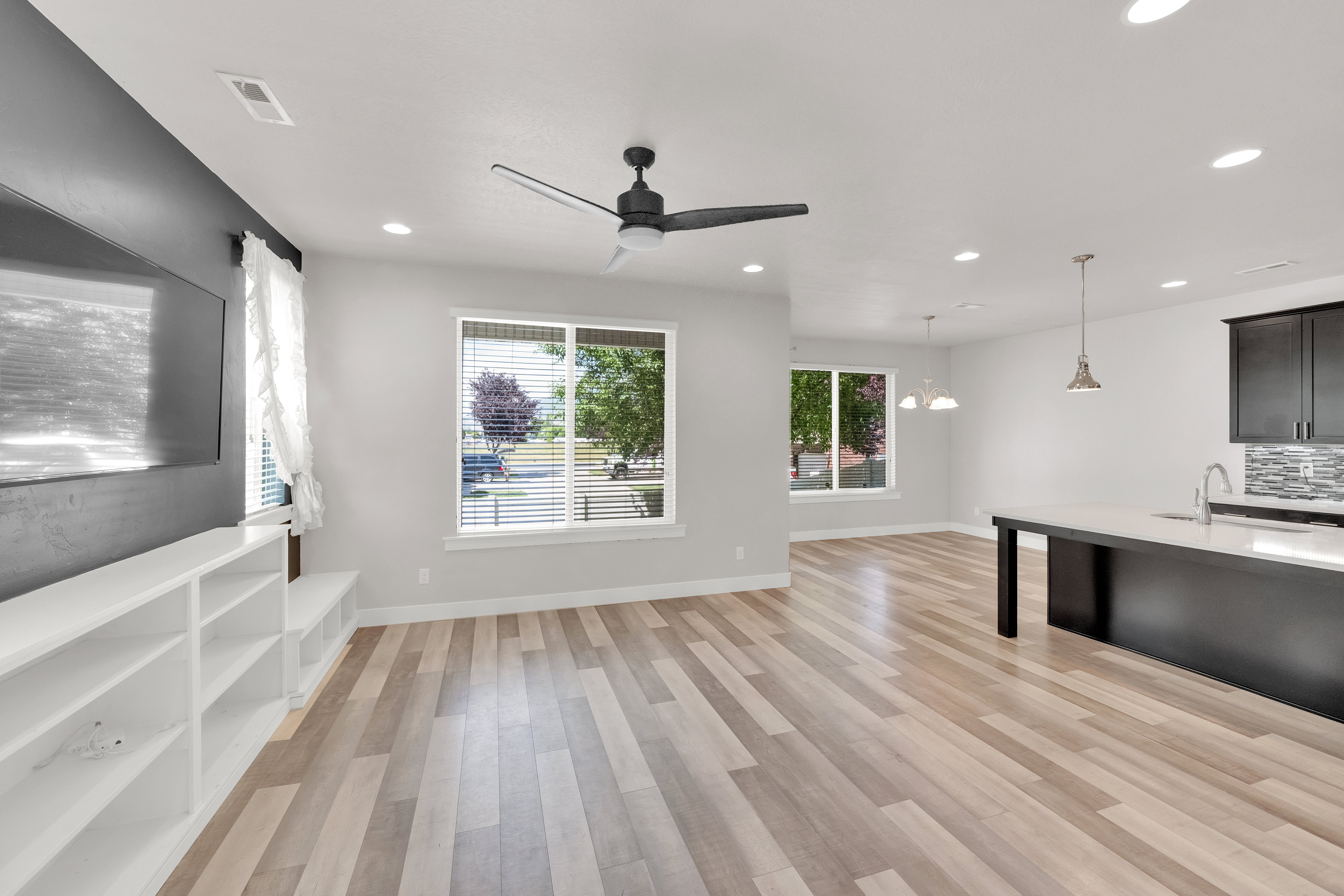 Open-concept living area featuring wood-finish flooring, recessed lighting, and a modern ceiling fan