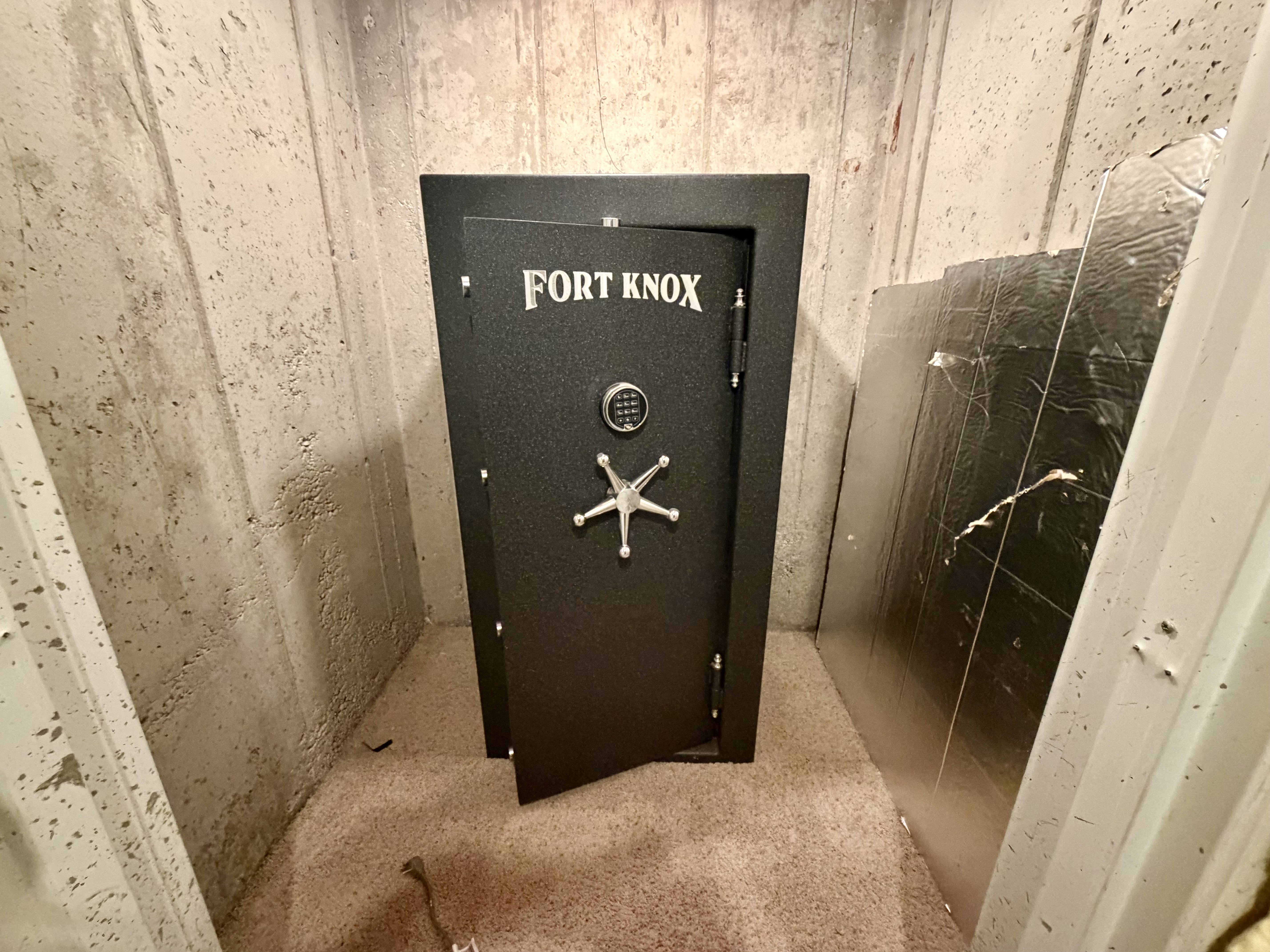 Integrated Fort Knox safe with combination lock and five-spoke handle, set on a carpeted floor