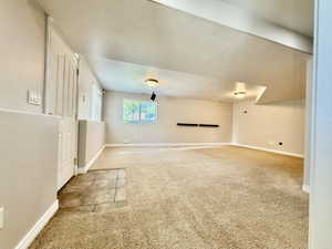 Spacious room featuring neutral carpeting, recessed ceiling lighting, and a window with blinds