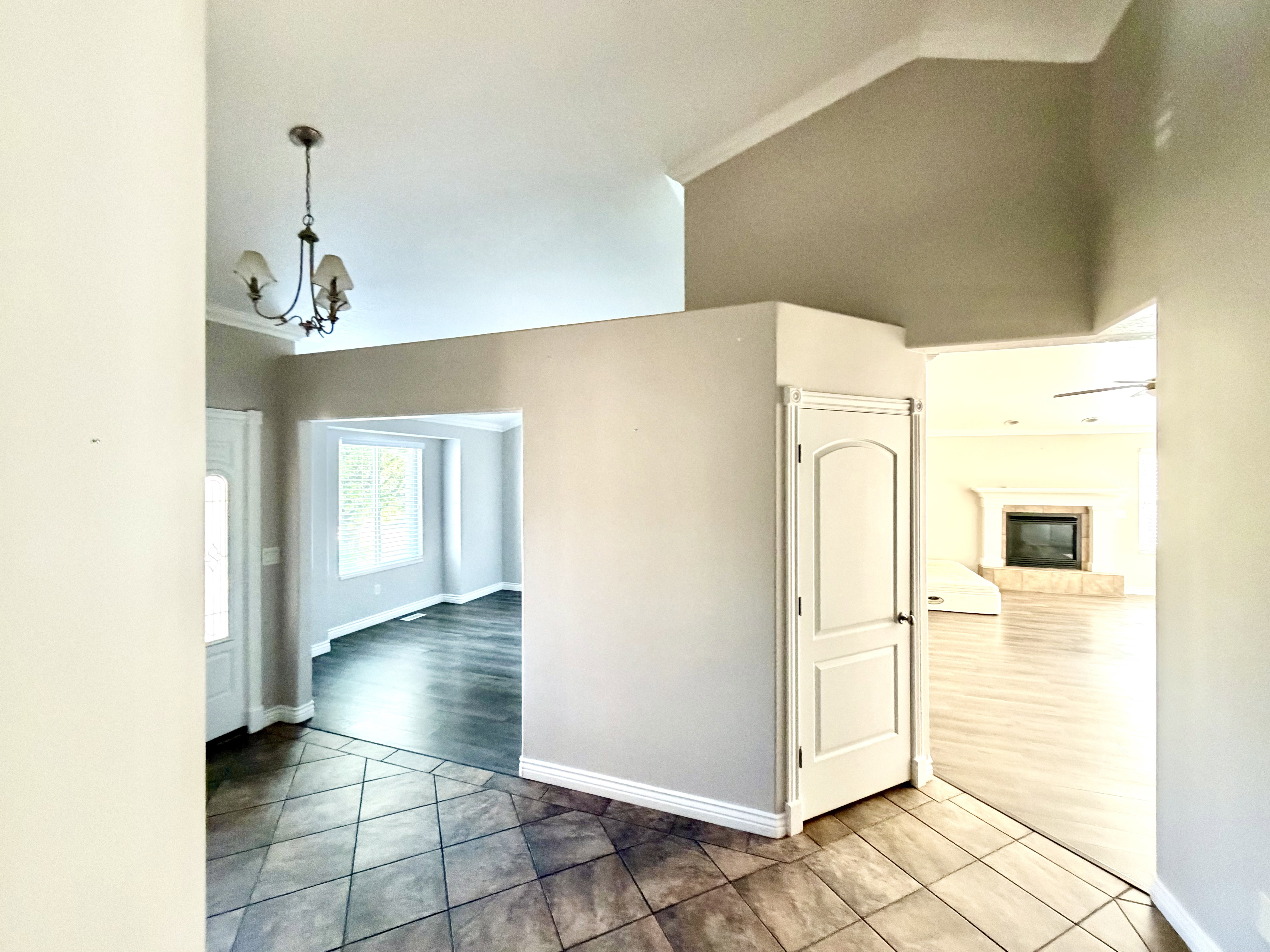 Entryway featuring tiled flooring, crown molding, and a chandelier