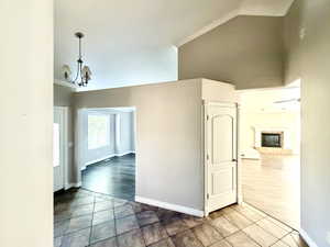 Entryway featuring tiled flooring, crown molding, and a chandelier