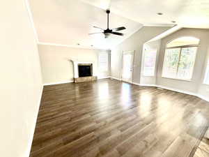 Vaulted ceilings with a ceiling fan, fireplace with a stone surround, wood-finish flooring, recessed lighting, and large bay windows with blinds