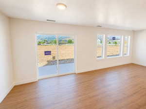 Room featuring light wood-finish flooring, white baseboards, and neutral wall paint