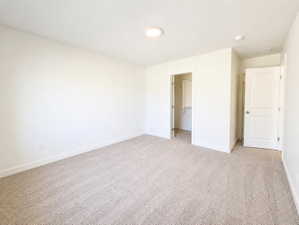 Carpeted room featuring a ceiling-mounted light fixture, white walls, and white baseboards