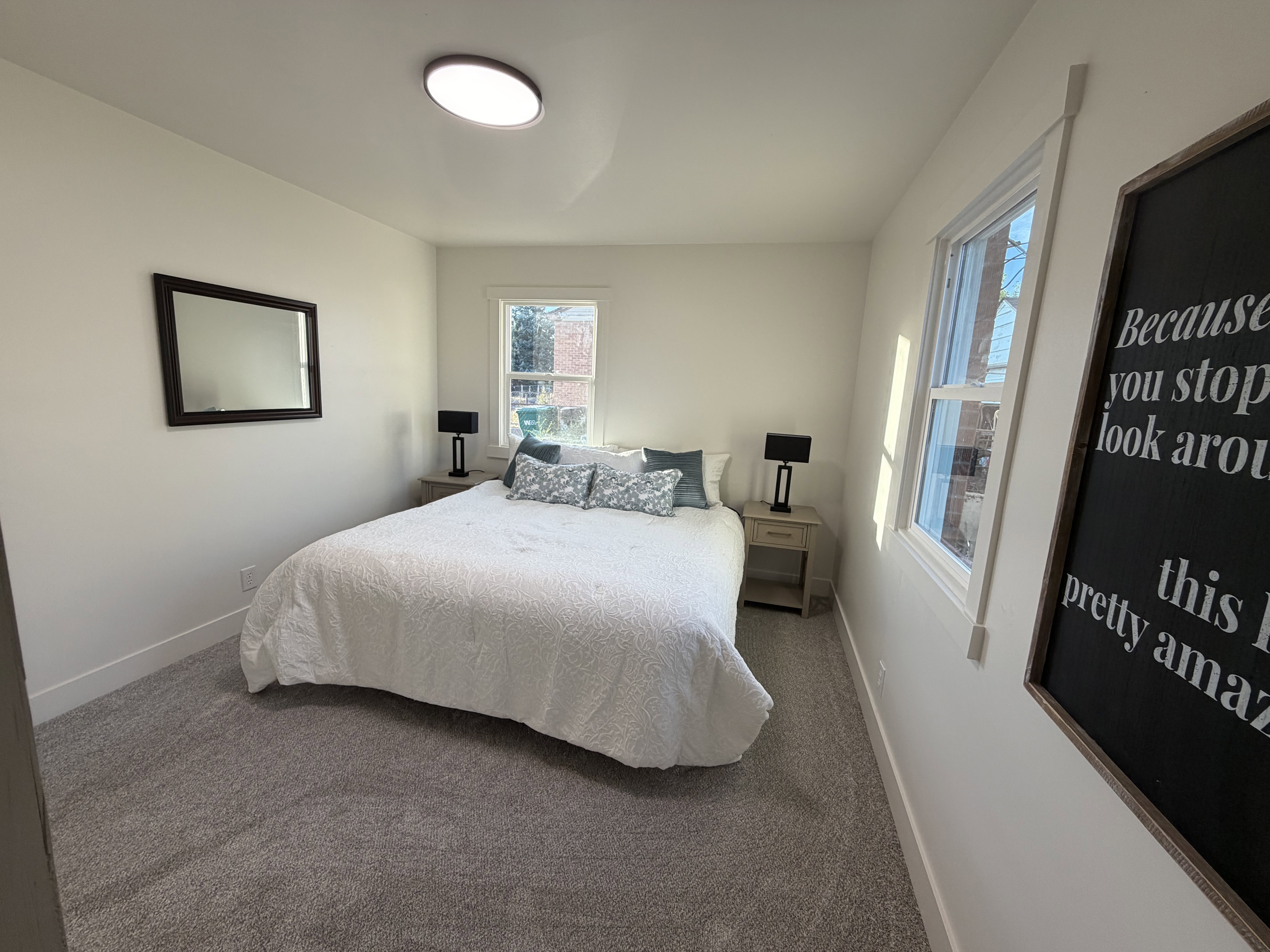 Carpeted bedroom with neutral wall tones and a circular flush-mount ceiling light