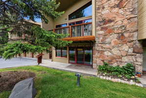 Exterior featuring diverse stone cladding and tan siding