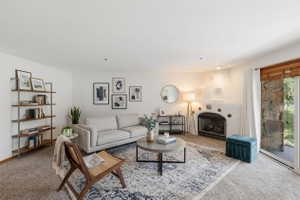 VIRTUAL  RENDERING: Spacious living area featuring a built-in fireplace, sliding glass door, and neutral carpeting