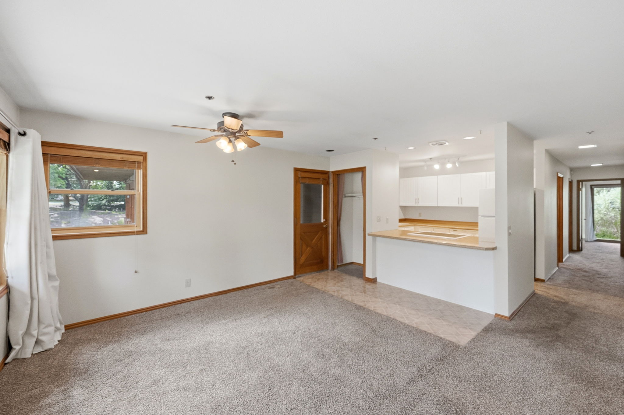 Open-concept living area featuring a breakfast bar, white cabinetry, and recessed lighting