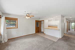 Open-concept living area featuring a breakfast bar, white cabinetry, and recessed lighting