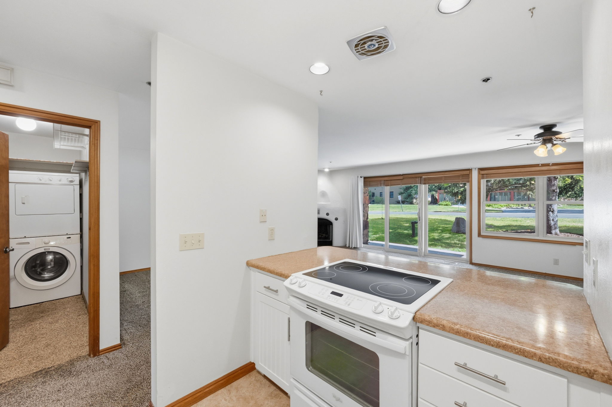 Kitchen featuring white cabinetry, light-colored countertops, and a white electric range