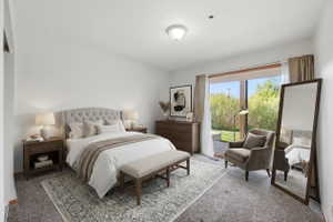 VIRTUAL  RENDERING:Light-filled bedroom featuring a large sliding glass door, white walls, and soft gray carpet
