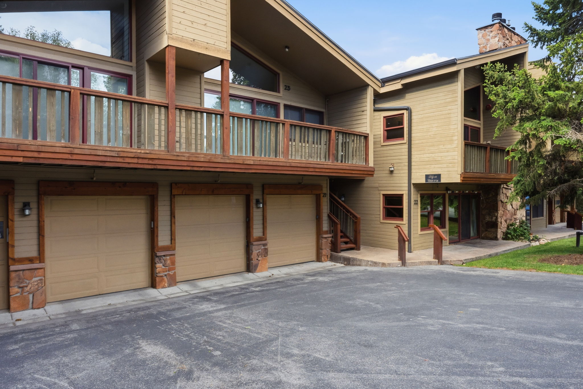 Second garage from the right unit 22.  Multi-level exterior featuring wood siding, stone accents, and multiple balconies
