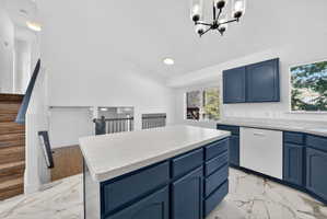 Kitchen featuring a central island with countertop, navy cabinetry, a built-in dishwasher, and a contemporary chandelier