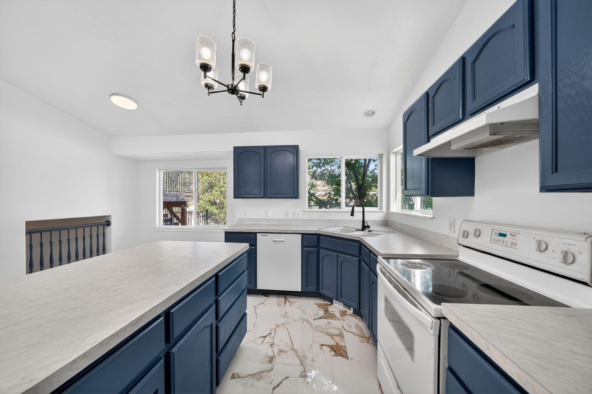 Kitchen featuring dark blue cabinetry with light-toned countertops