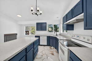 Kitchen featuring dark blue cabinetry with light-toned countertops