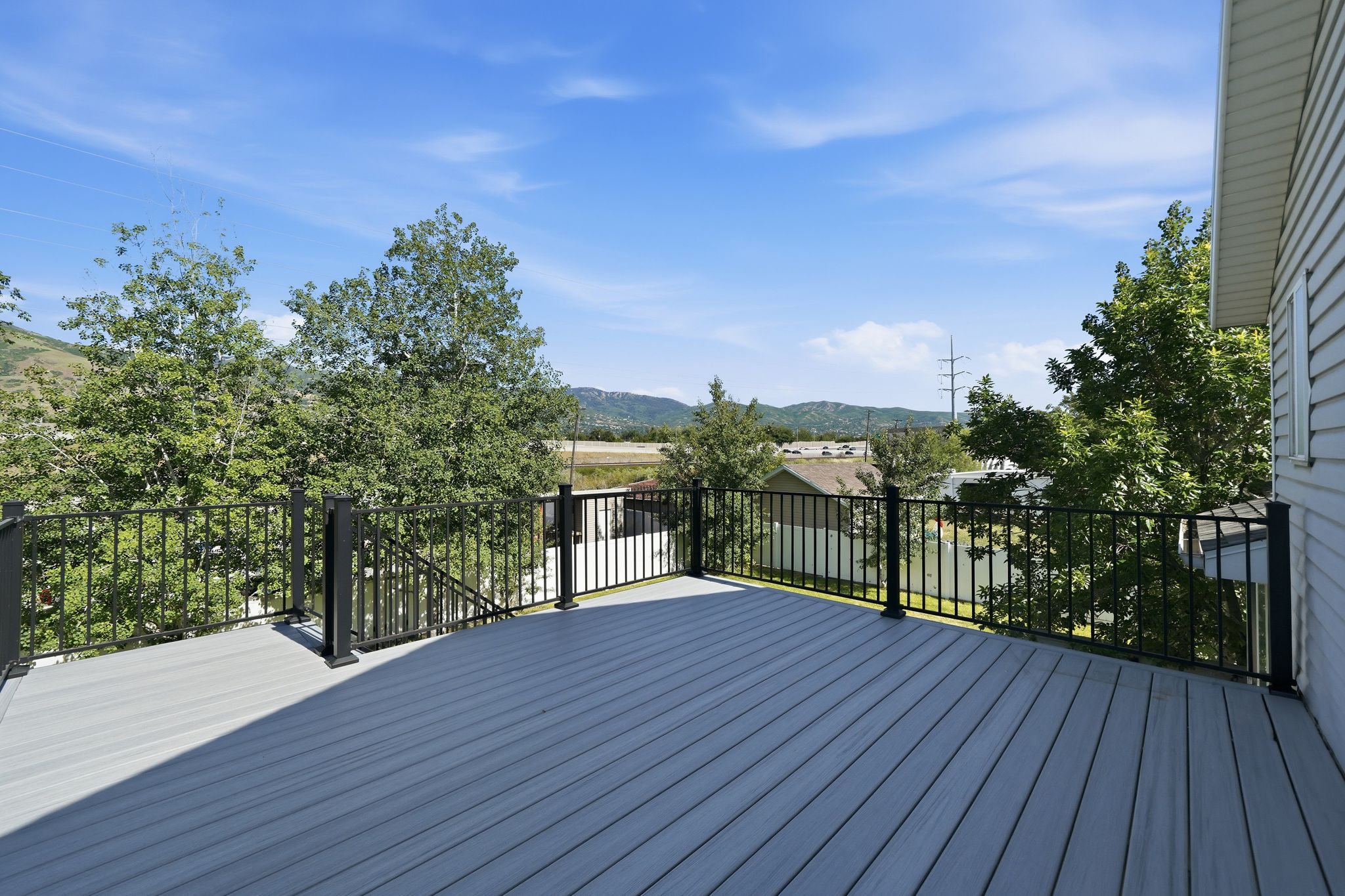 Expansive outdoor deck featuring composite decking and black metal railings