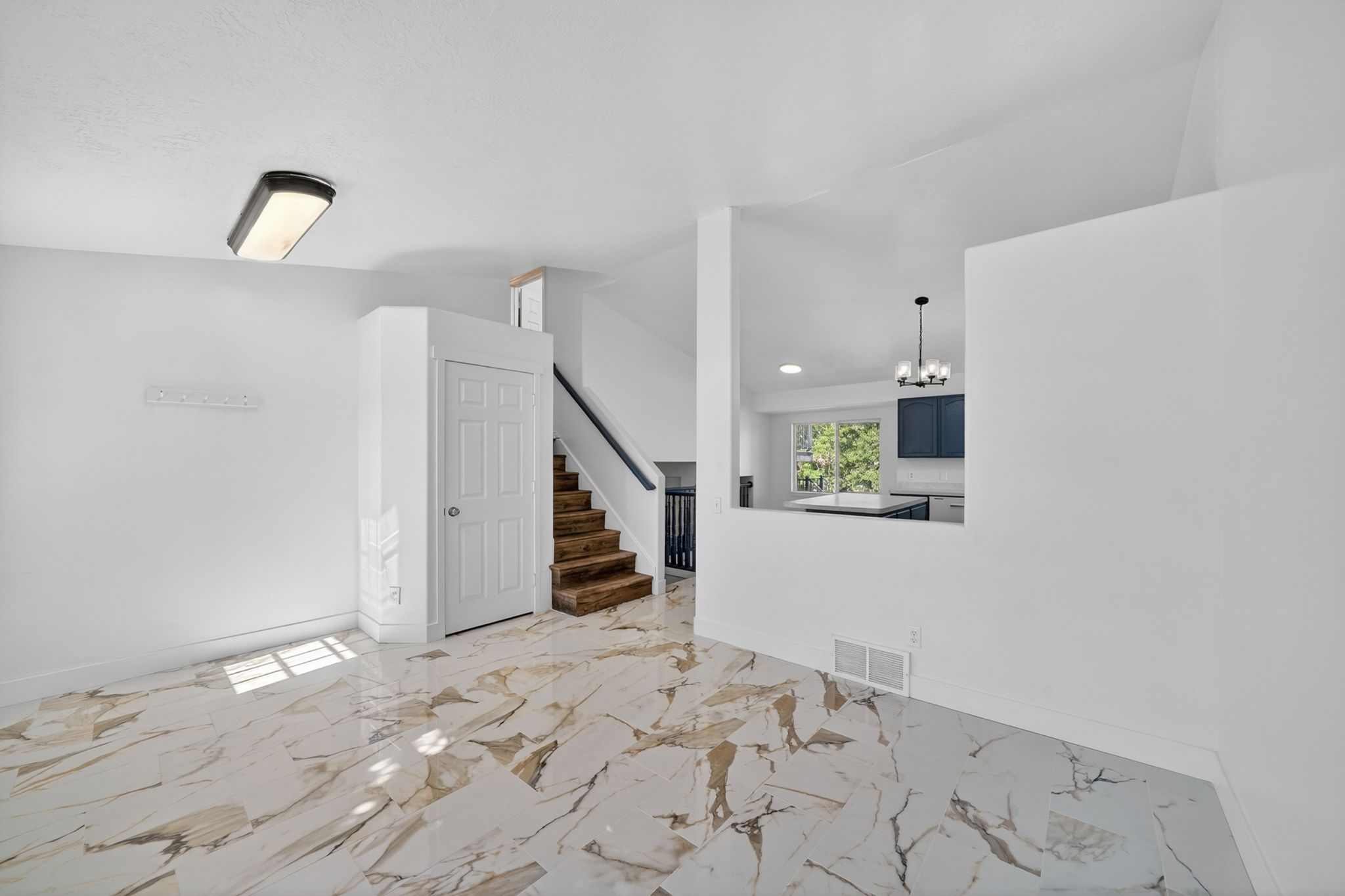 Spacious entry area with large format marble-look tile flooring