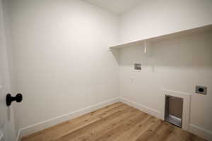 Utility room with wood-finish flooring, white walls, and built-in shelving