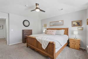 Carpeted bedroom featuring a vaulted ceiling and a ceiling fan with integrated lighting