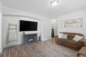 Living area featuring an arched alcove with shiplap accent wall, wood-finish flooring, and recessed lighting