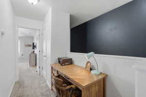 Dedicated desk area featuring a wood-finish desktop and dark accent wall