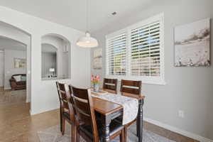 Dining area featuring a wood-finish table, four matching chairs, and a contemporary pendant light fixture