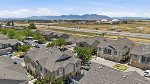 Aerial perspective of residential community featuring multi-story homes with shingle roofs and integrated garages