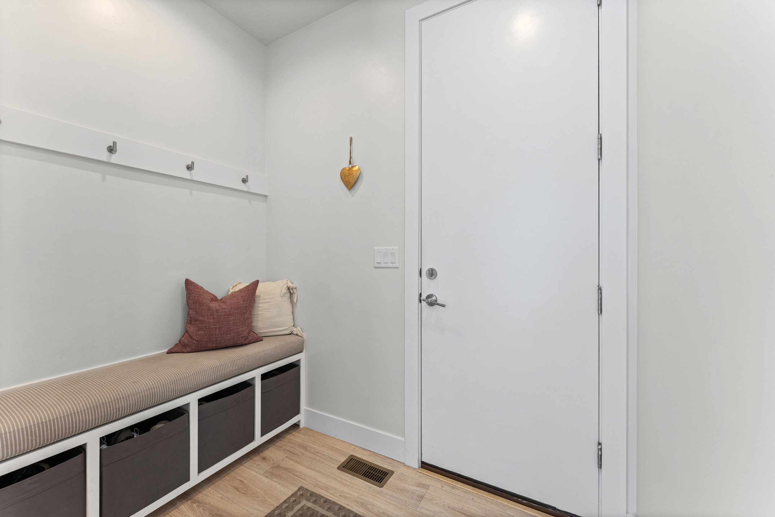 Entryway with wood-finish flooring and a built-in bench featuring cubby storage
