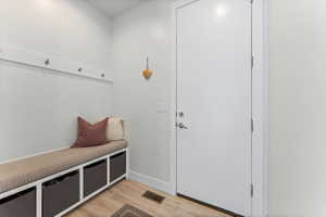 Entryway with wood-finish flooring and a built-in bench featuring cubby storage