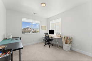 Spacious room featuring neutral carpeting, light-colored walls, and two large windows with white blinds