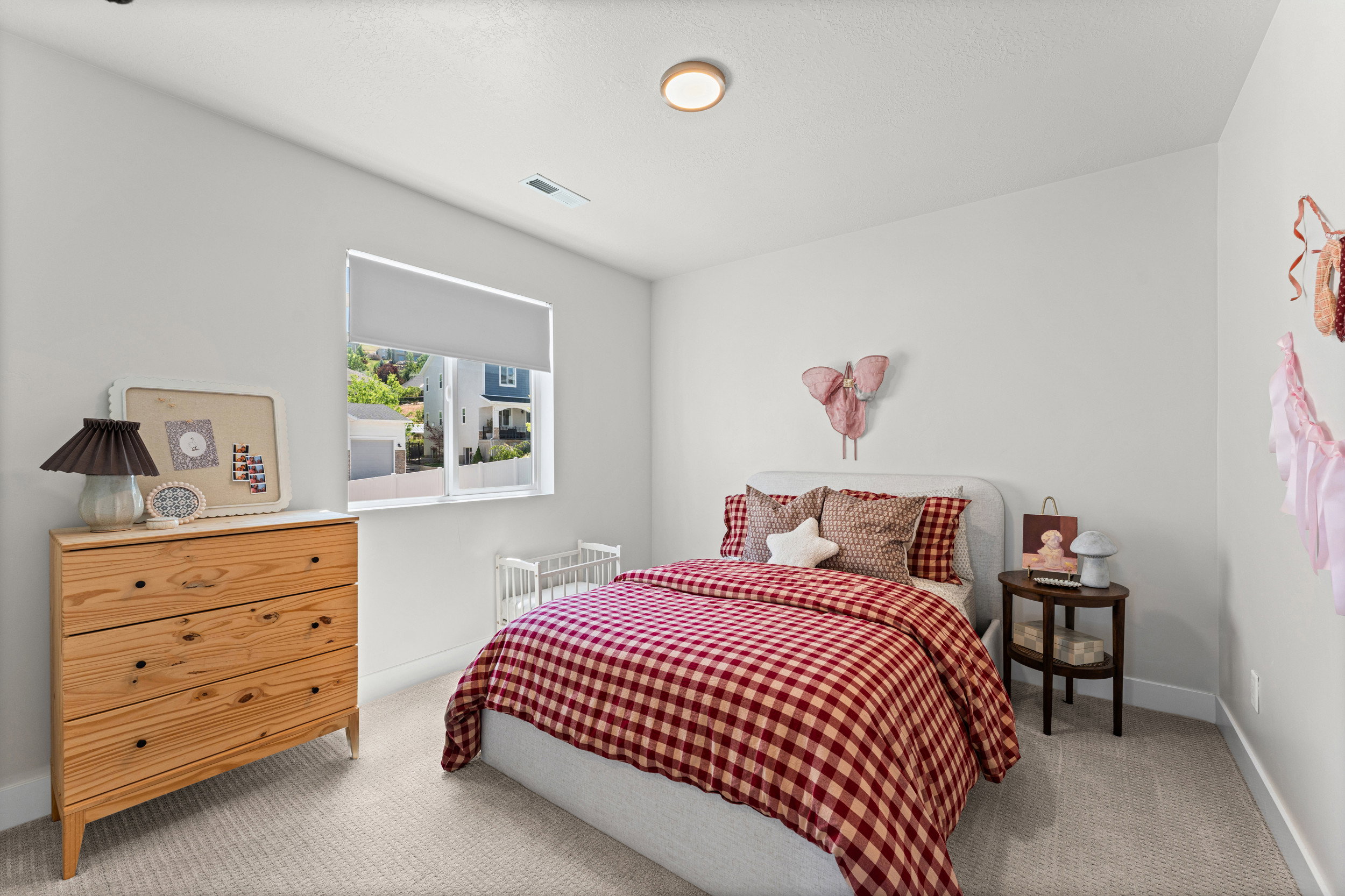 Neutral wall paint, light-colored carpet flooring, recessed lighting, and a single window with roller shade