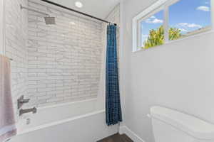 Bathroom featuring white subway tile shower surround with geometric accents, brushed nickel fixtures, a white soaking tub, and a window providing natural light