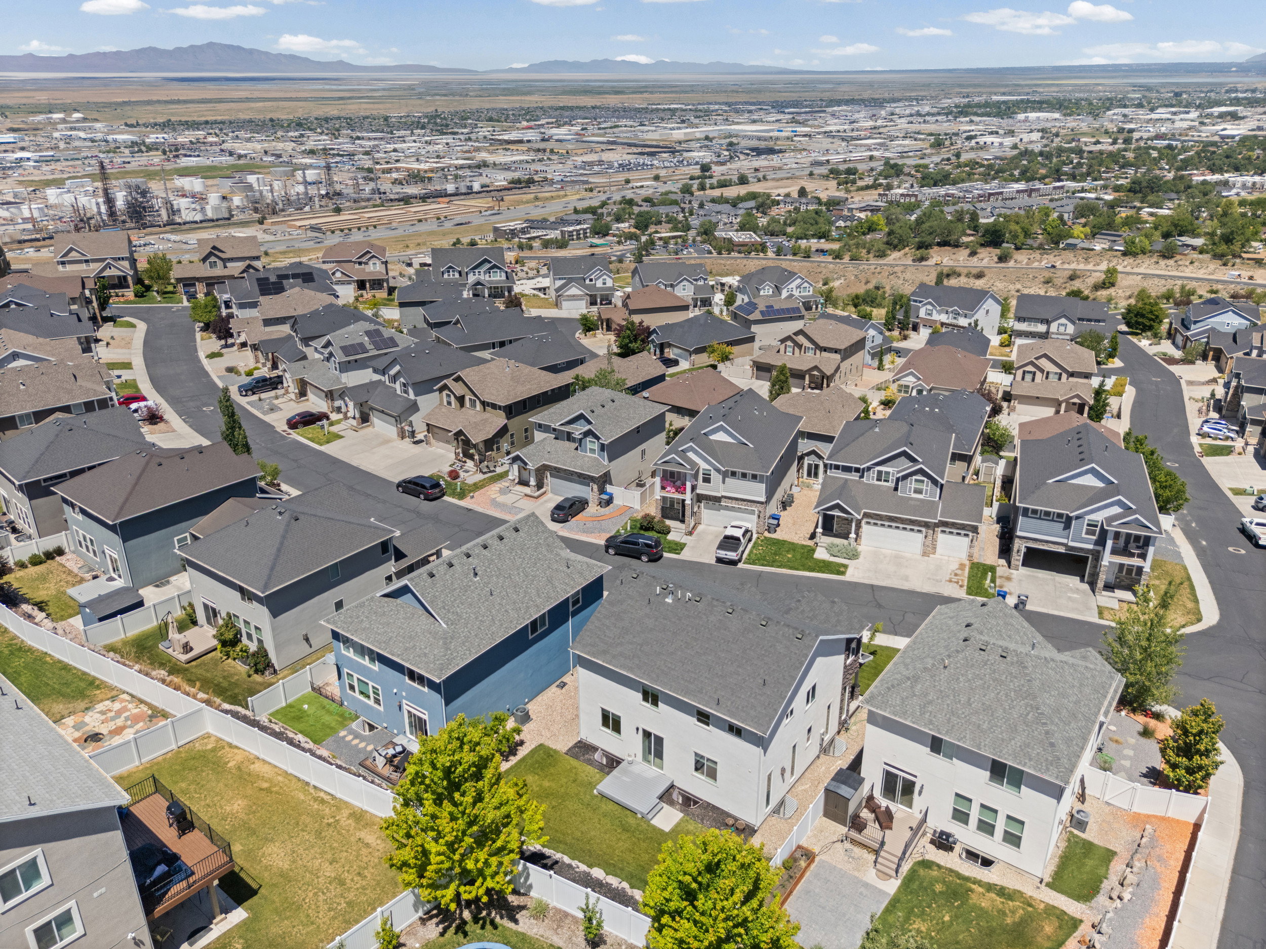 Aerial view of a residential neighborhood with diverse architectural styles, paved streets, and varied landscaping
