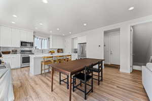 Open-concept kitchen and dining area featuring wood-finish flooring