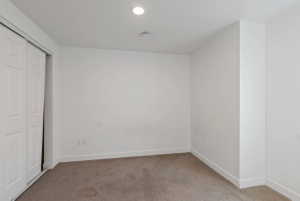 Room featuring carpet flooring, white walls, white baseboards, and a recessed ceiling light