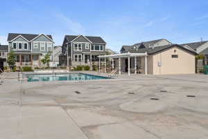 Outdoor swimming pool with integrated steps, surrounded by a concrete deck and bordered by a low stone wall