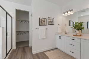 Bathroom featuring a dual vanity with white cabinetry and a light-toned countertop