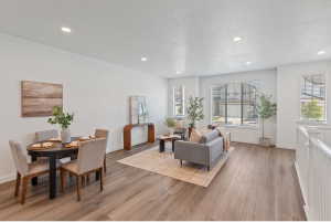 Open-concept living space with wood-finish flooring, recessed lighting, and white walls