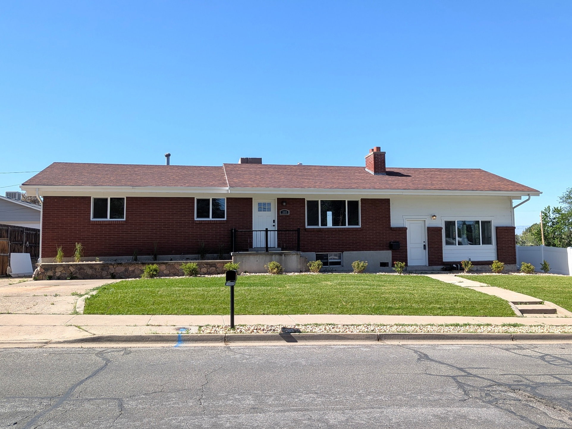 Single-story ranch-style residence featuring a brick facade and white siding