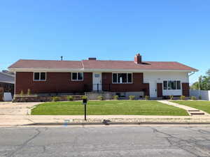 Single-story ranch-style residence featuring a brick facade and white siding