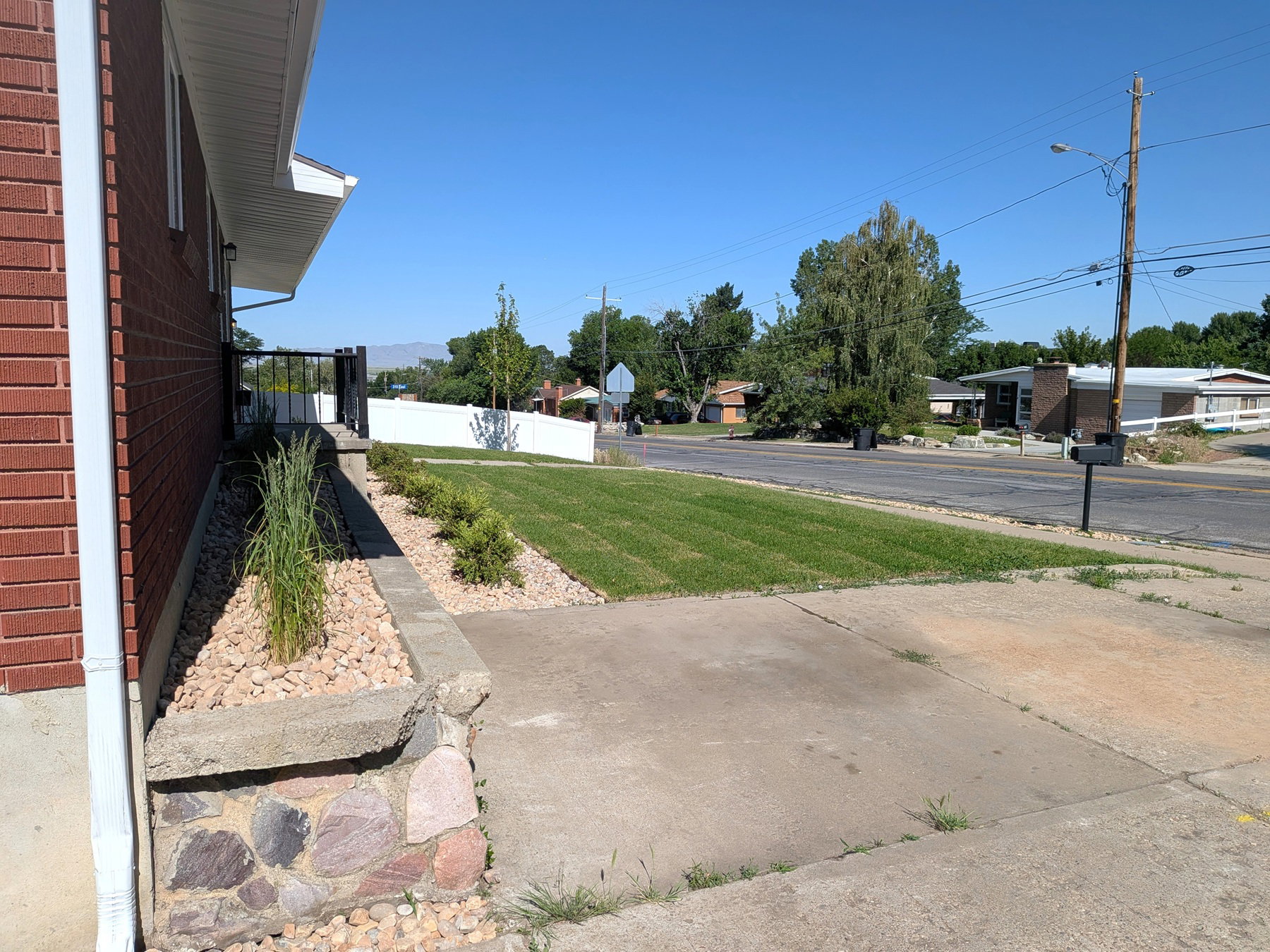 Brick exterior featuring white trim and a concrete driveway