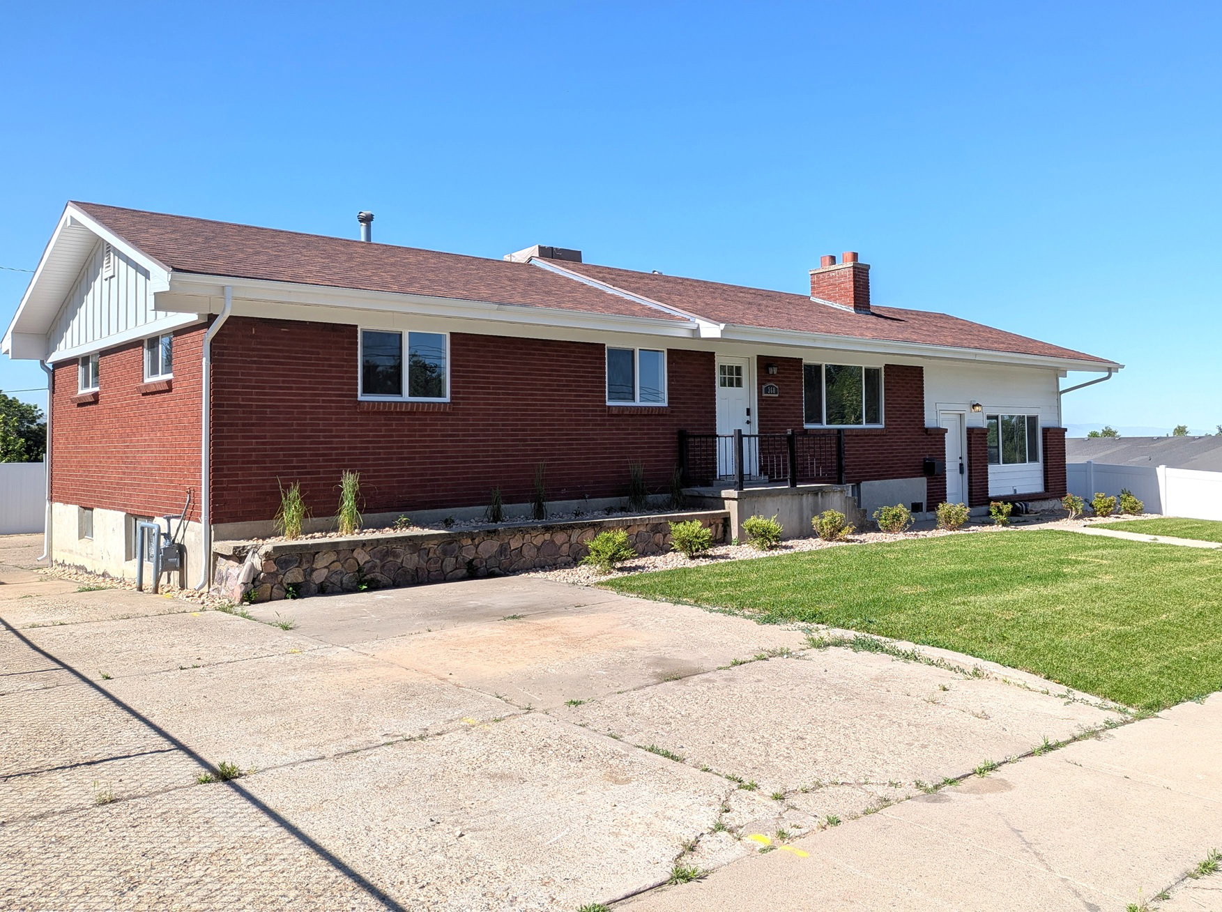 Brick and white siding facade with a brown shingle roof