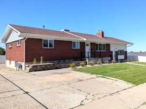 Brick and white siding facade with a brown shingle roof