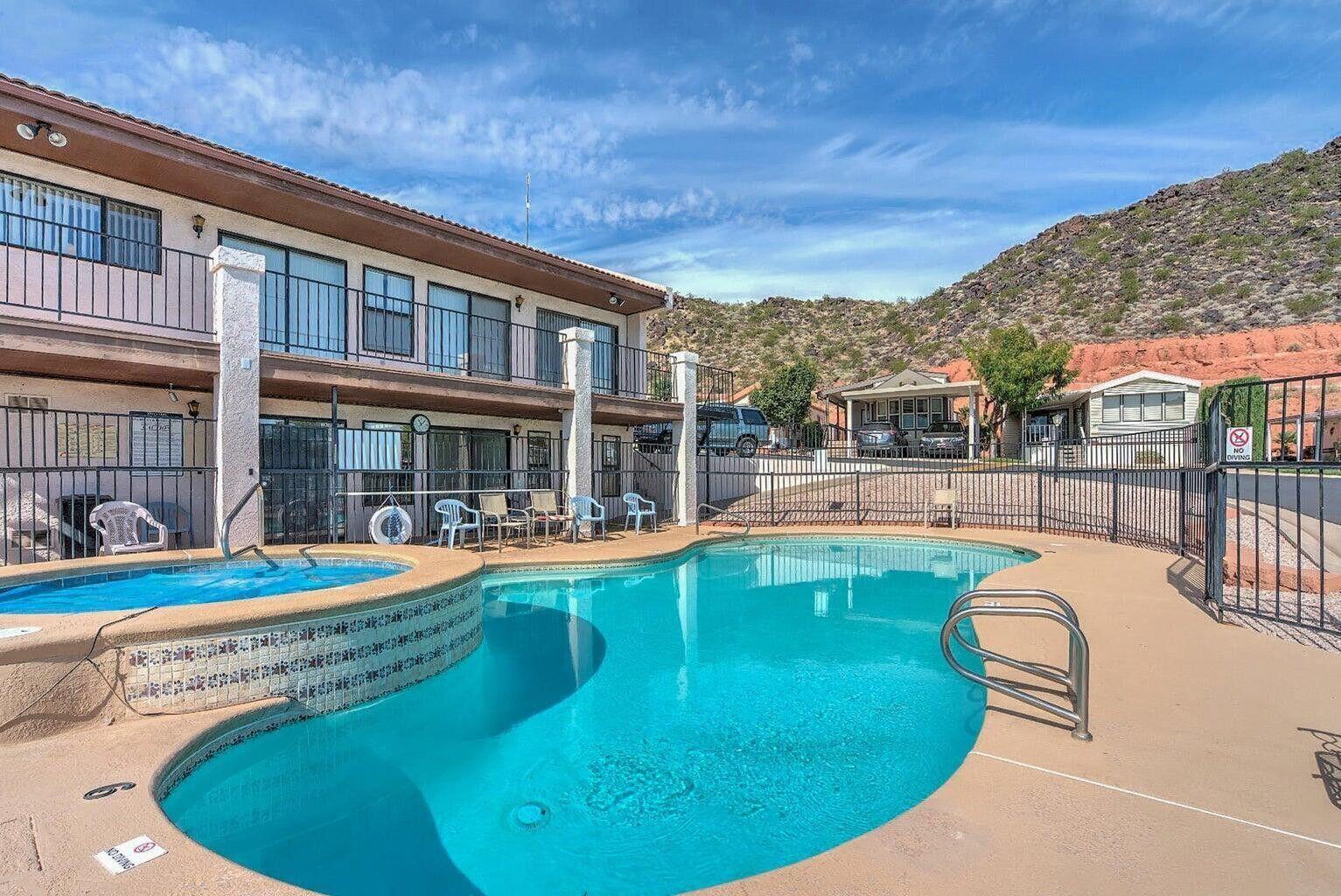 Curved swimming pool with integrated spa and surrounding patio