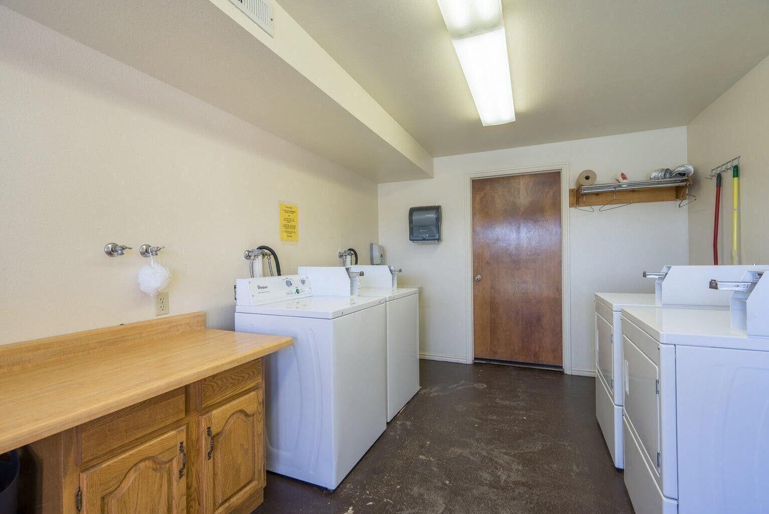 Dedicated laundry area featuring multiple washing machines and dryers