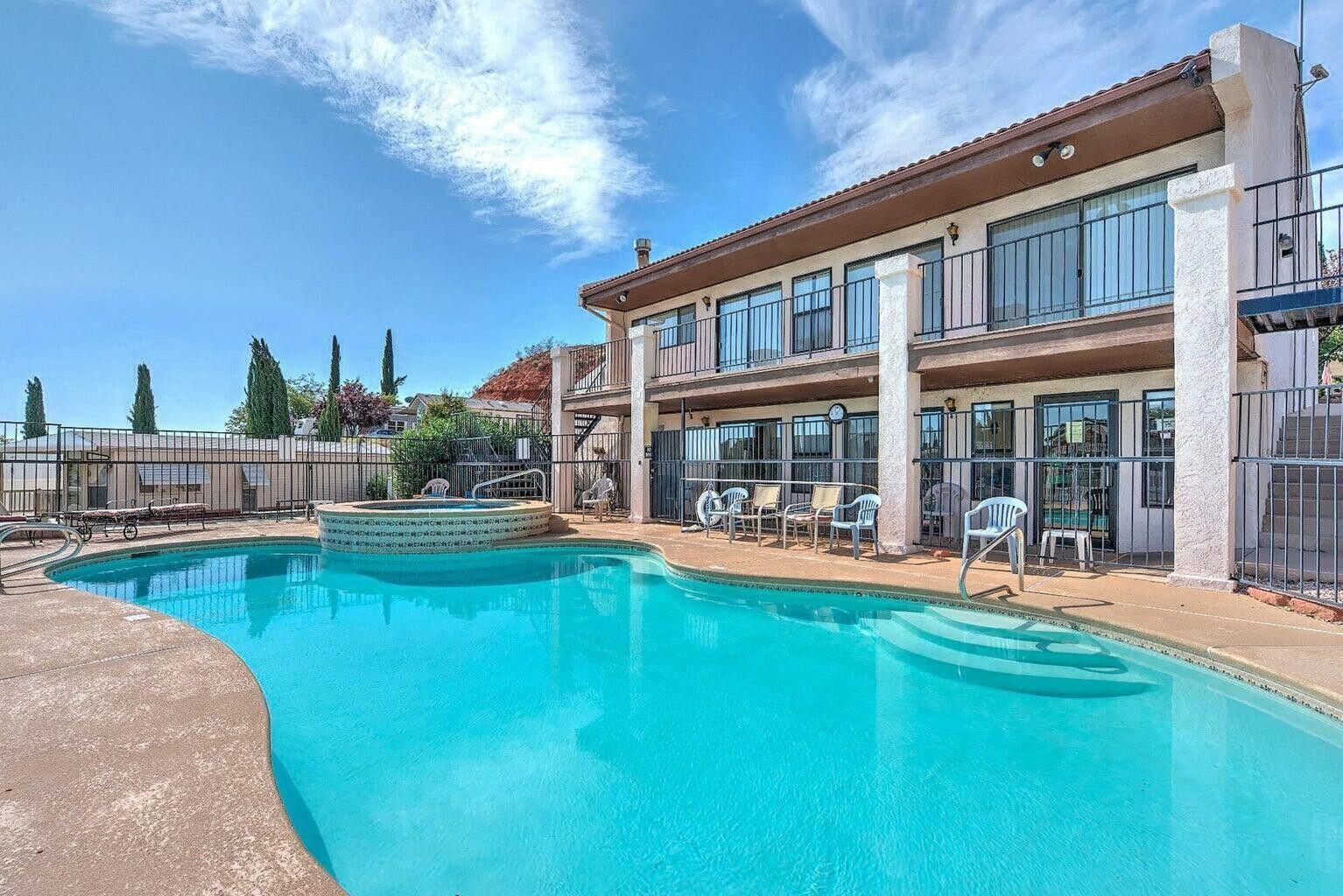 Outdoor swimming pool with integrated spa and concrete decking
