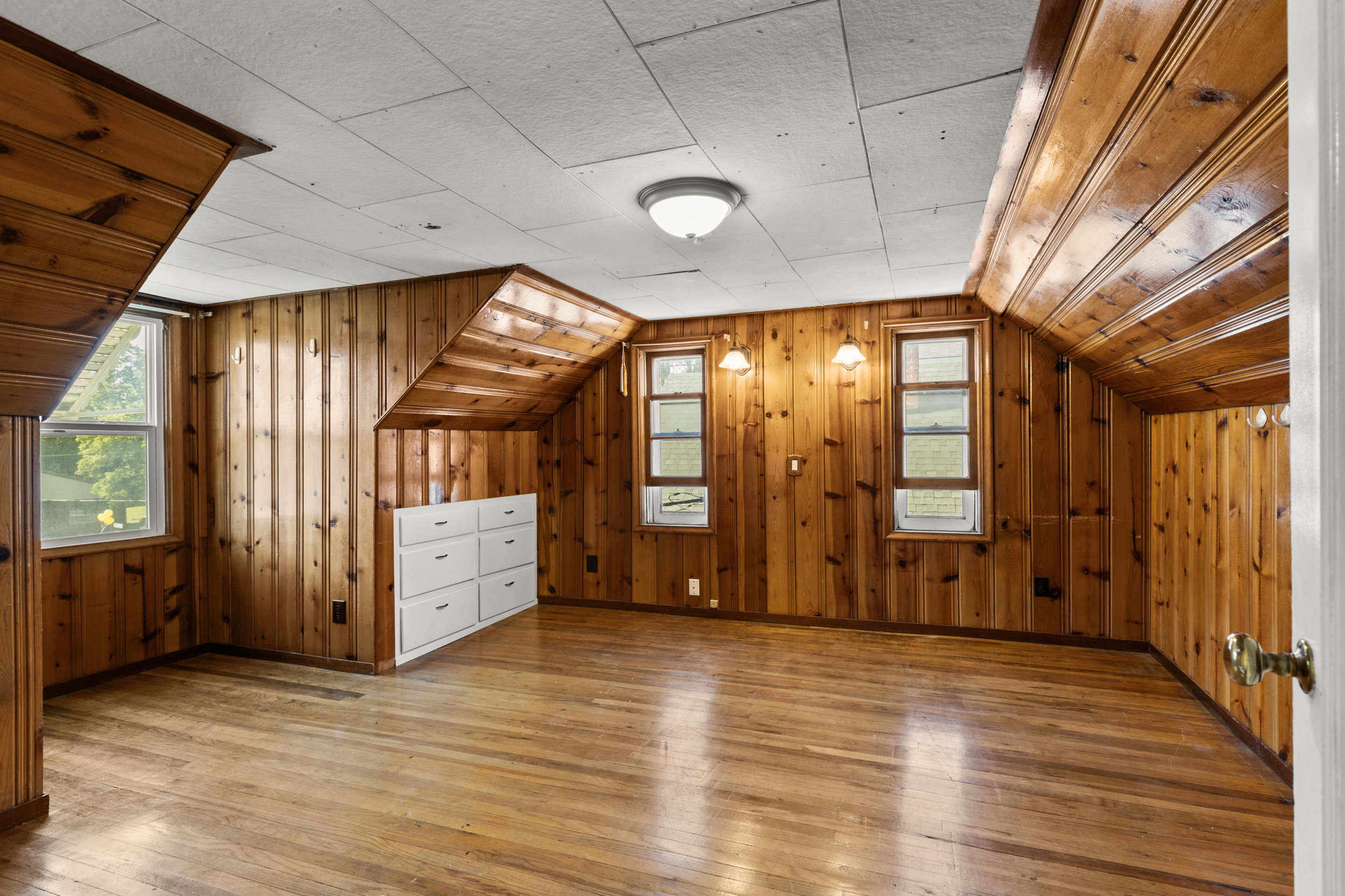 Room featuring warm wood-paneled walls and wood-finish flooring