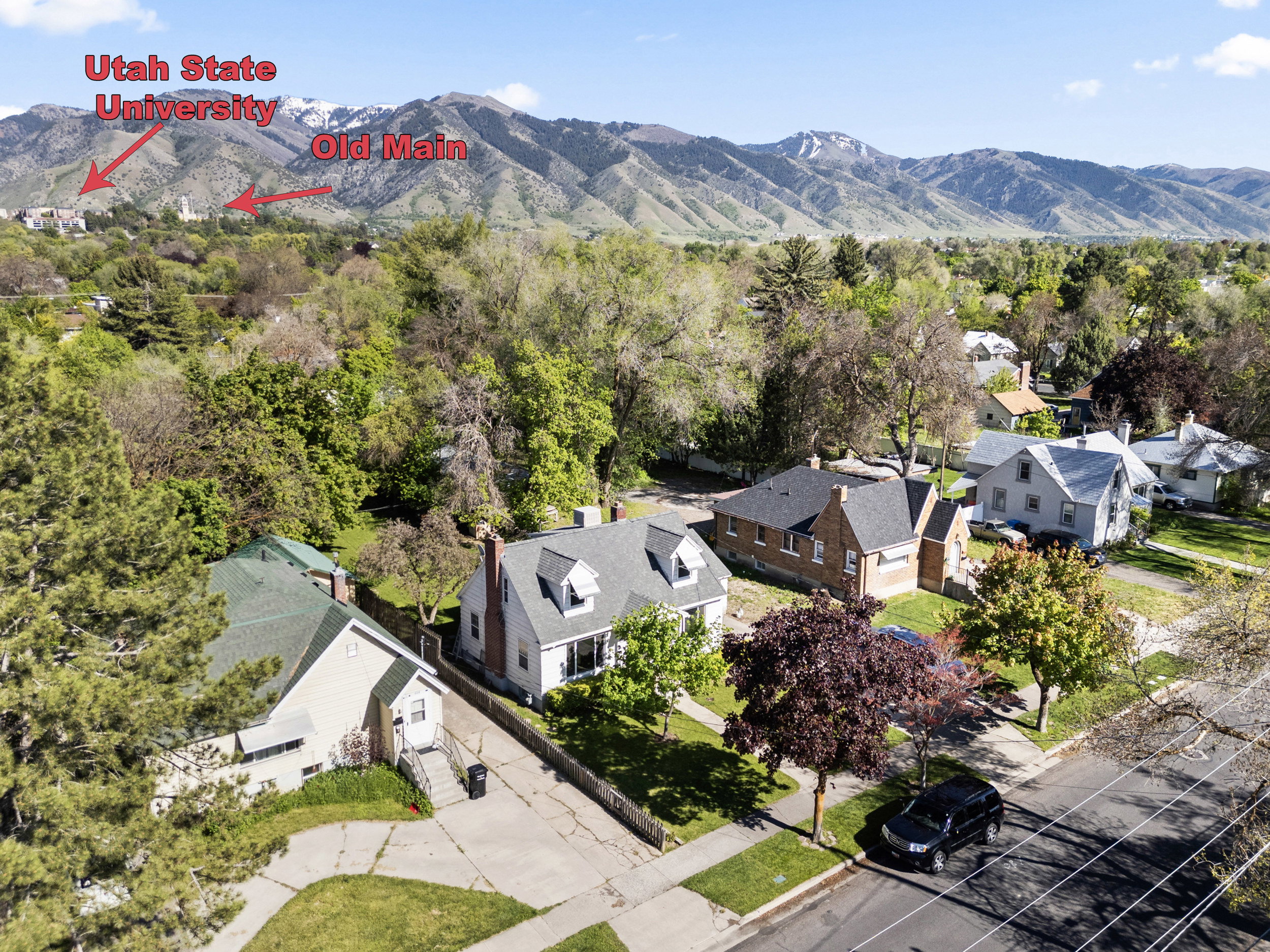 Neighborhood setting with mountain backdrop and mature trees